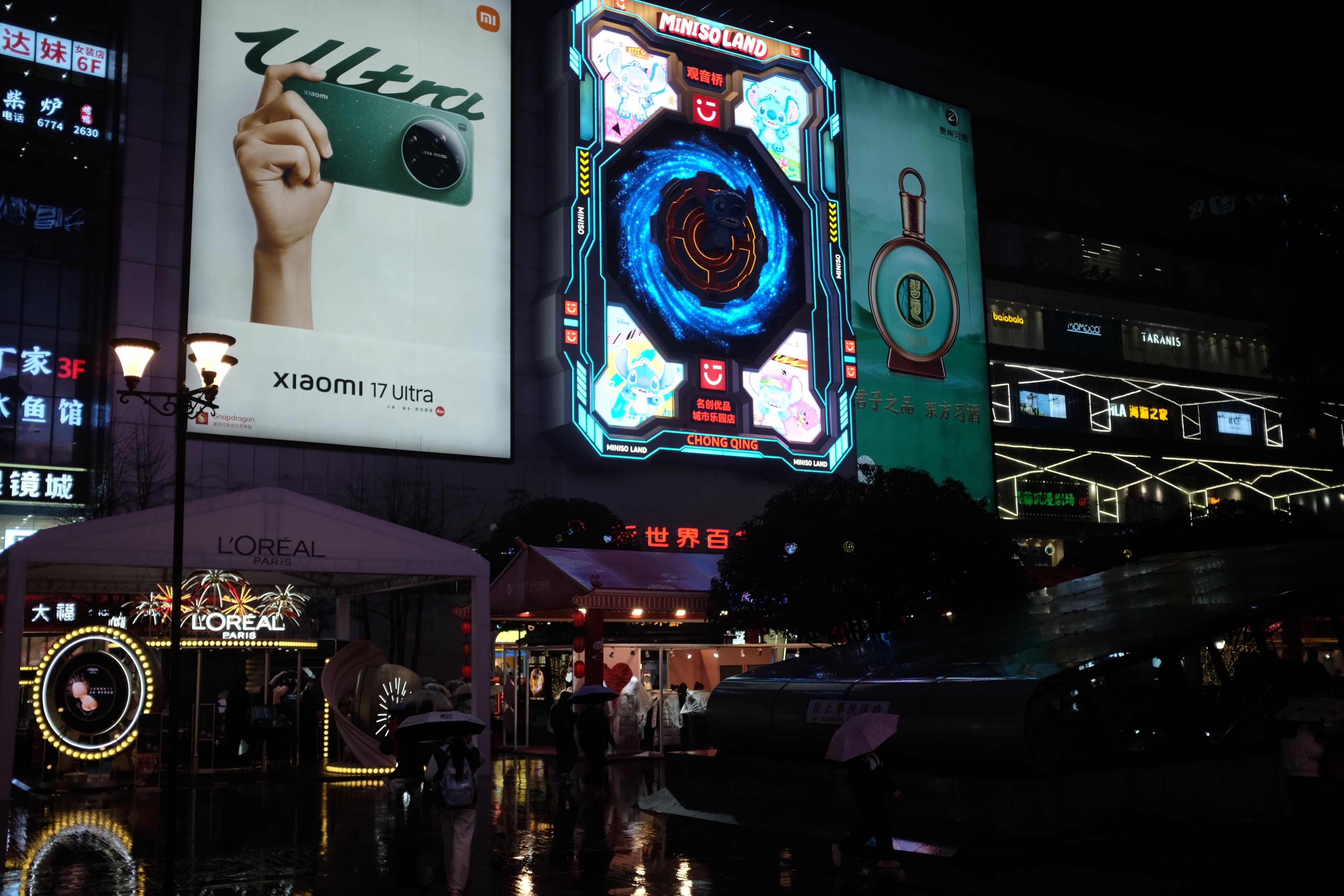 Vibrant urban street at night with illuminated billboards and digital ads