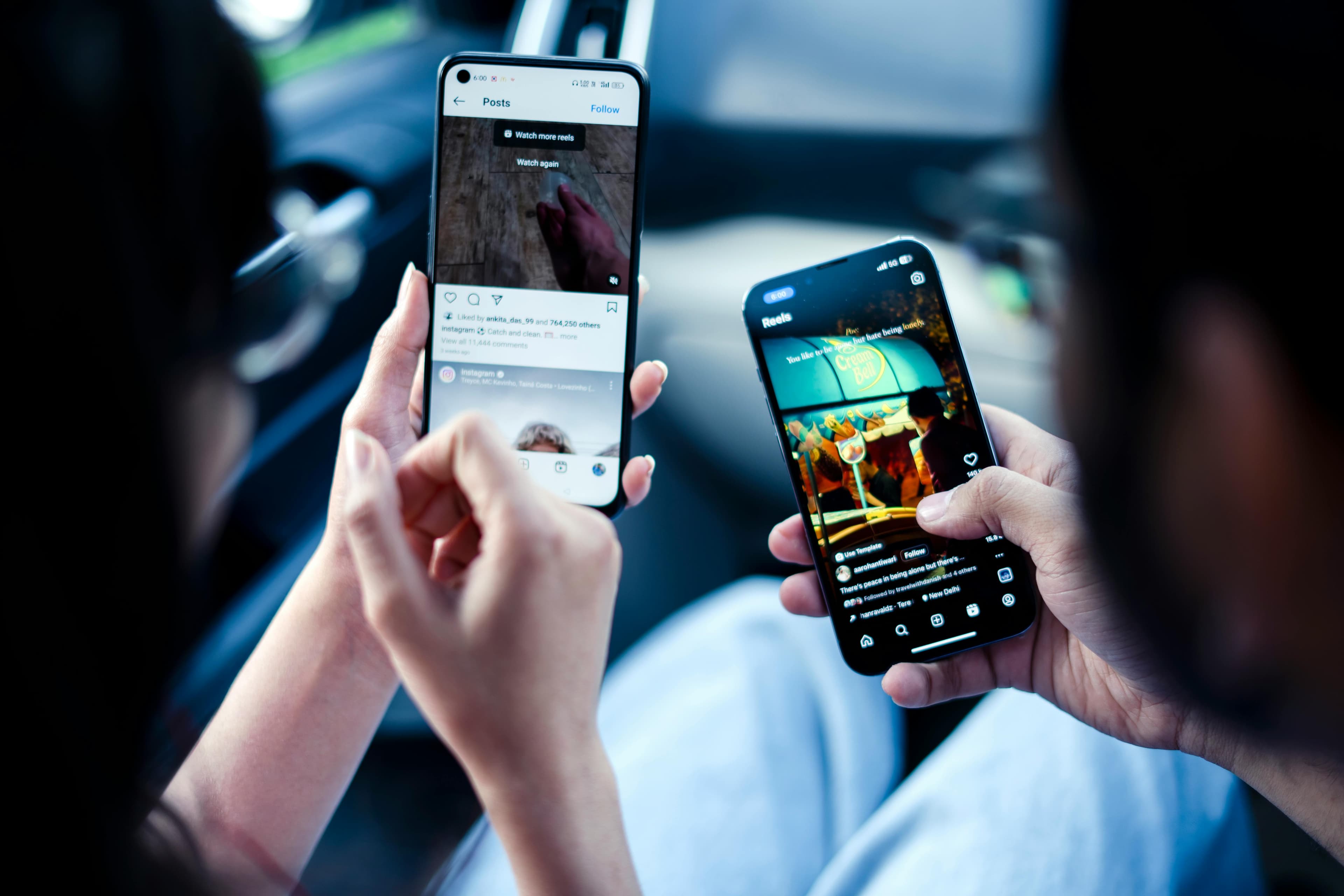 Two people looking at smartphones engaging with social media content