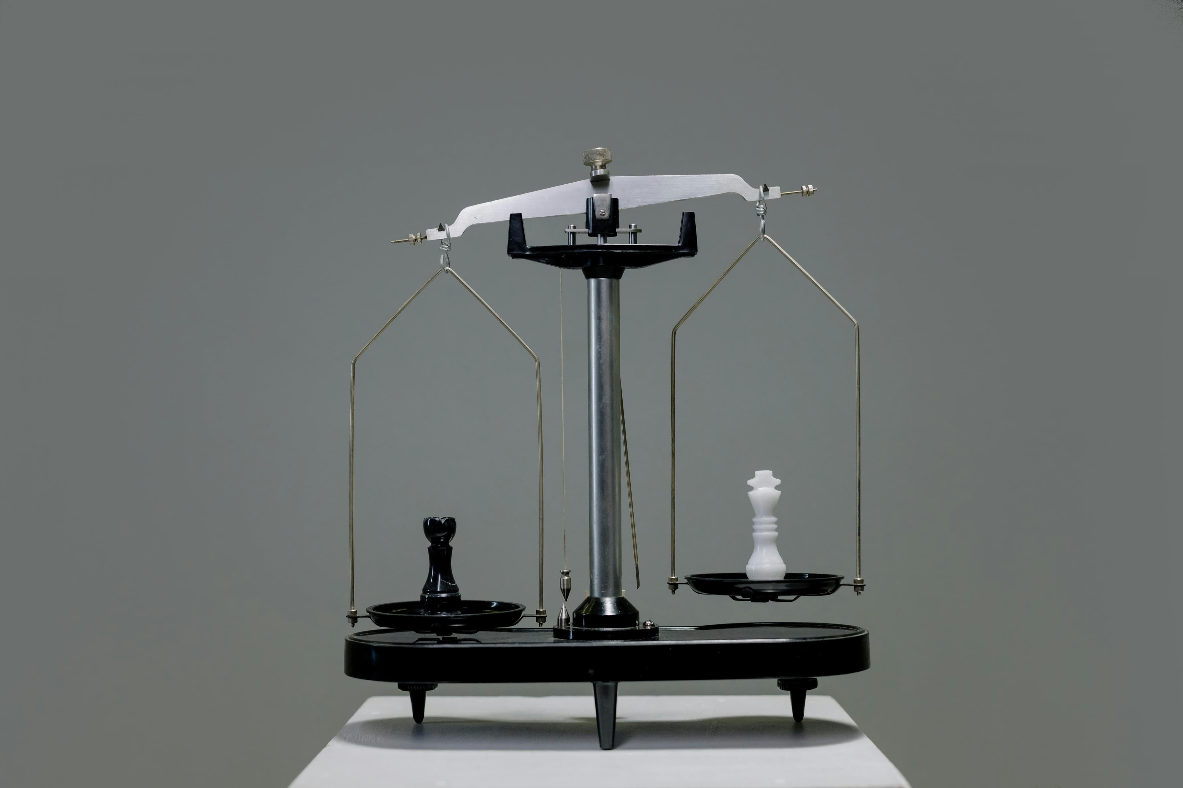 Chess pieces balanced on a scale representing a comparison or decision